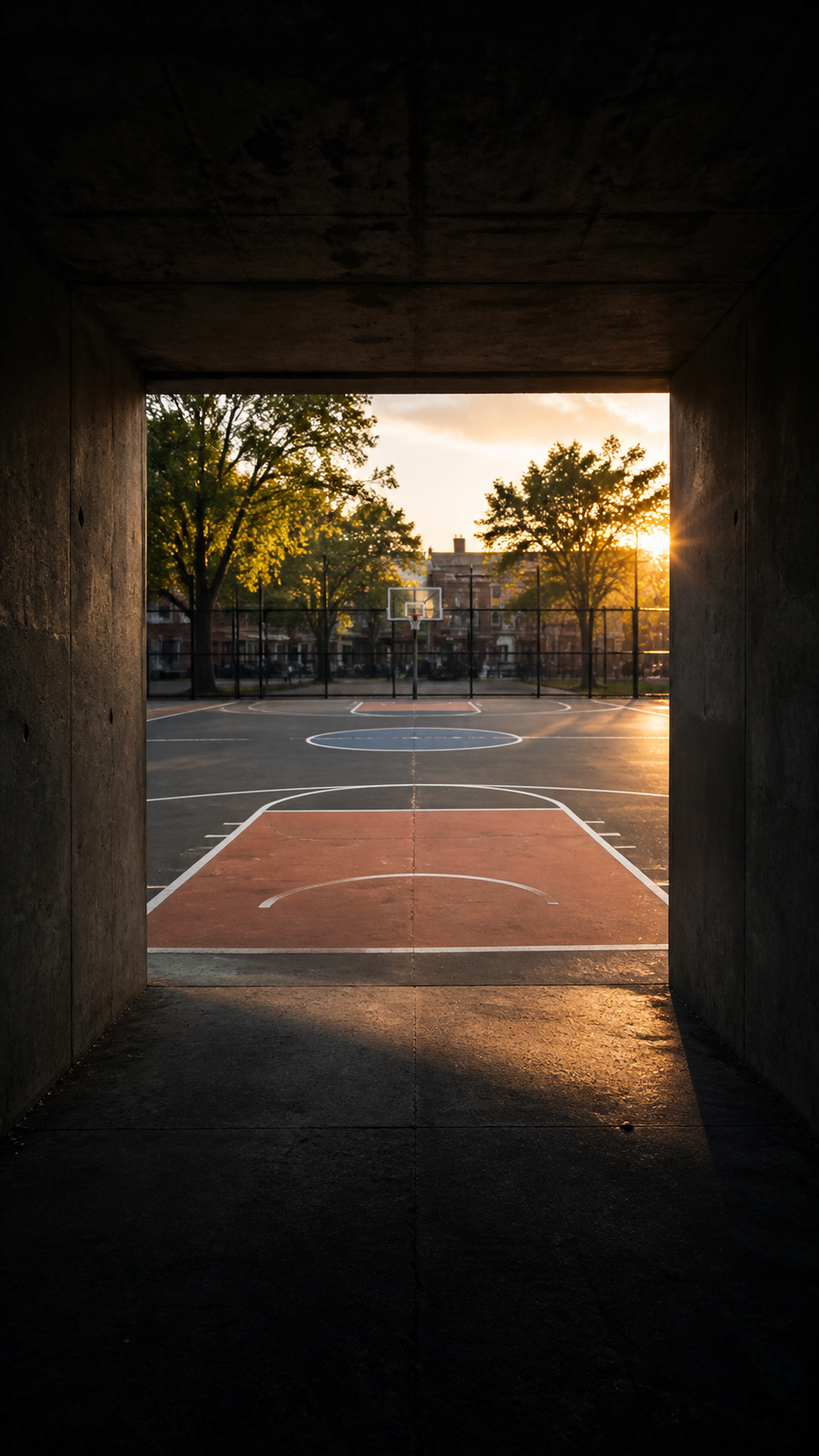 Outdoor basketball court viewed through the players tunnel